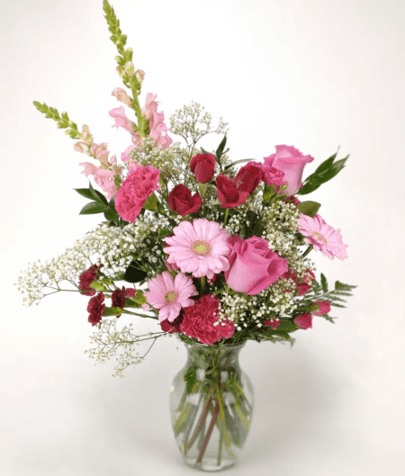 Wasn't it just yesterday someone lightened and brightened your day? Today, you can return the favor with this charming arrangement. Burgundy roses, pink carnations, gerberas and larkspur arrive stylishly arranged in a clear glass vase.
