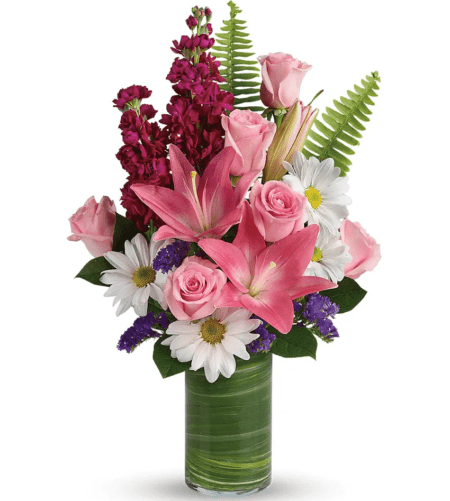 Bright, happy daisies and pink roses dance with elegant pink lilies and fabulous fuchsia stock in this playful bouquet! Wrapped with a leaf in a modern cylinder vase, it's a joyful gift for any occasion.
