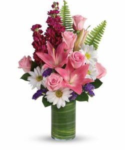 Bright white daisies and pink roses dance with happy pink lilies and fabulous fuchsia stock in this playful bouquet! Wrapped with a ti leaf in a modern cylinder vase, it's a joyful gift for any occasion.